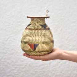 hand holding a light patterned woven vase