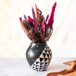 Large black and white patterned soap stone vase with dried flower arrangement